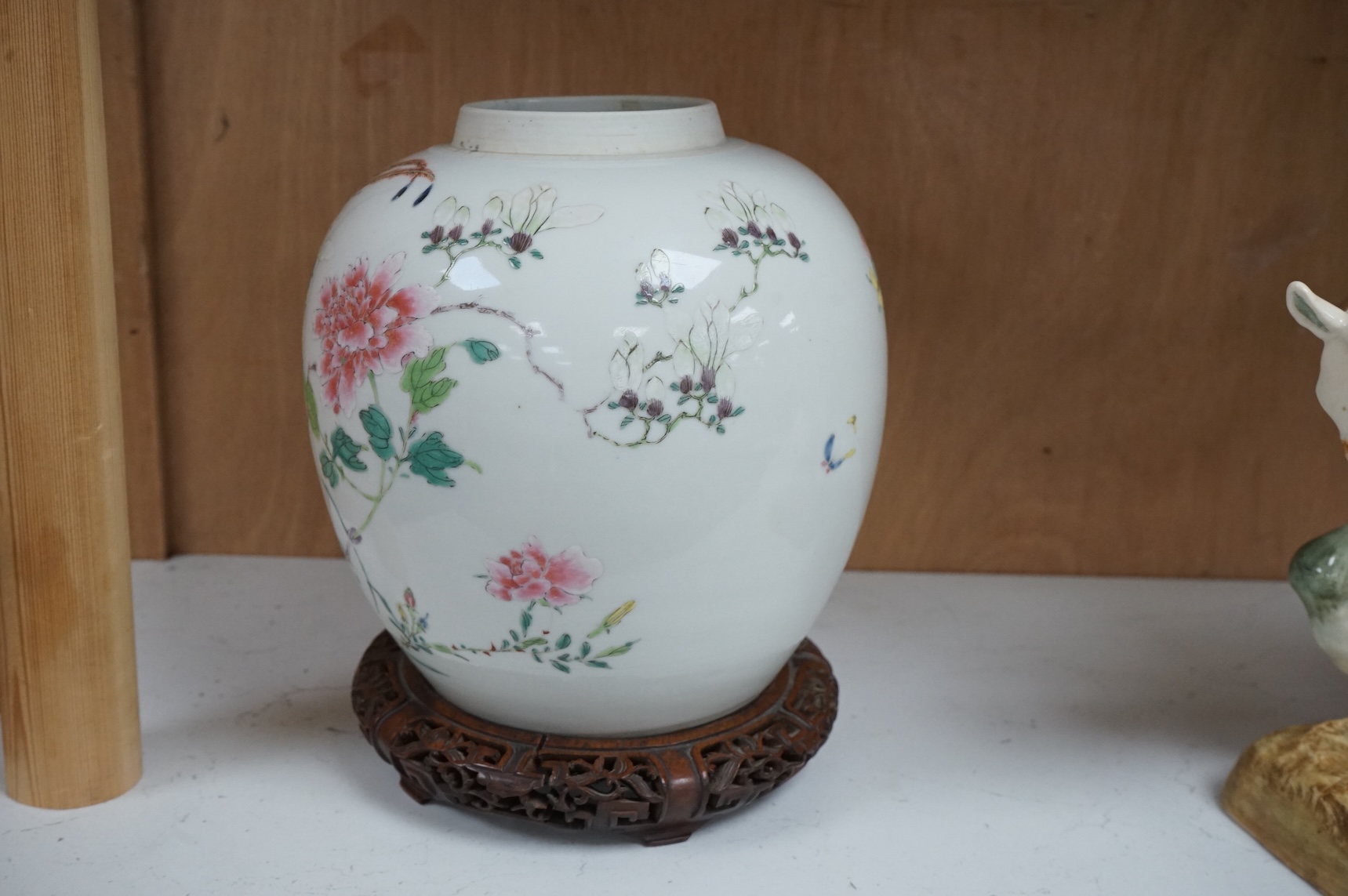 A late 19th century Chinese famille rose 'pheasant' jar lacking cover, with finely carved wooden stand, 21.5cm high including stand.